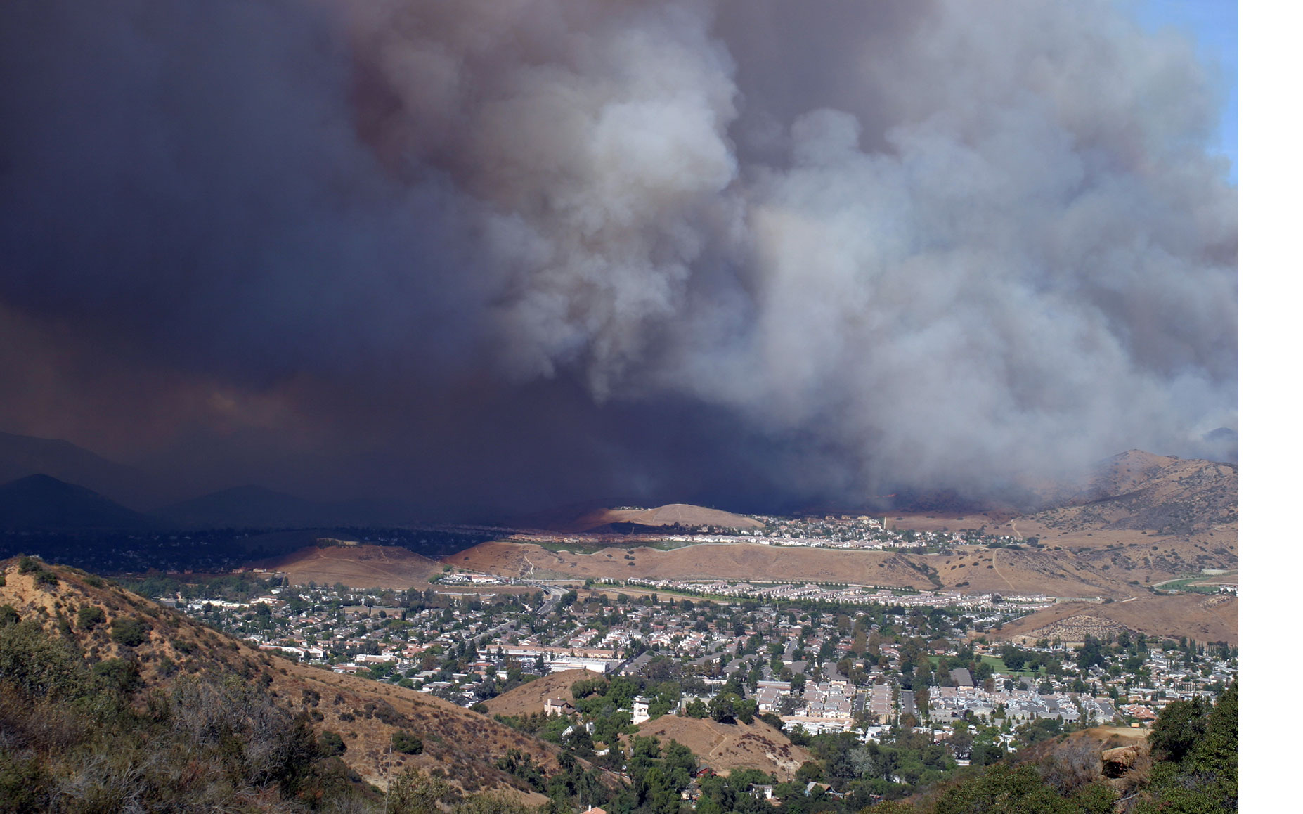 A community of houses with wildfire smoke nearby