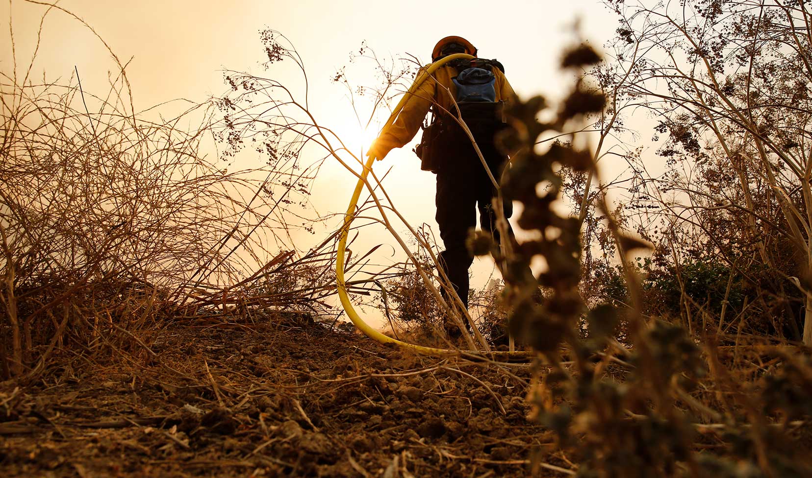 firefighter hauling water lines