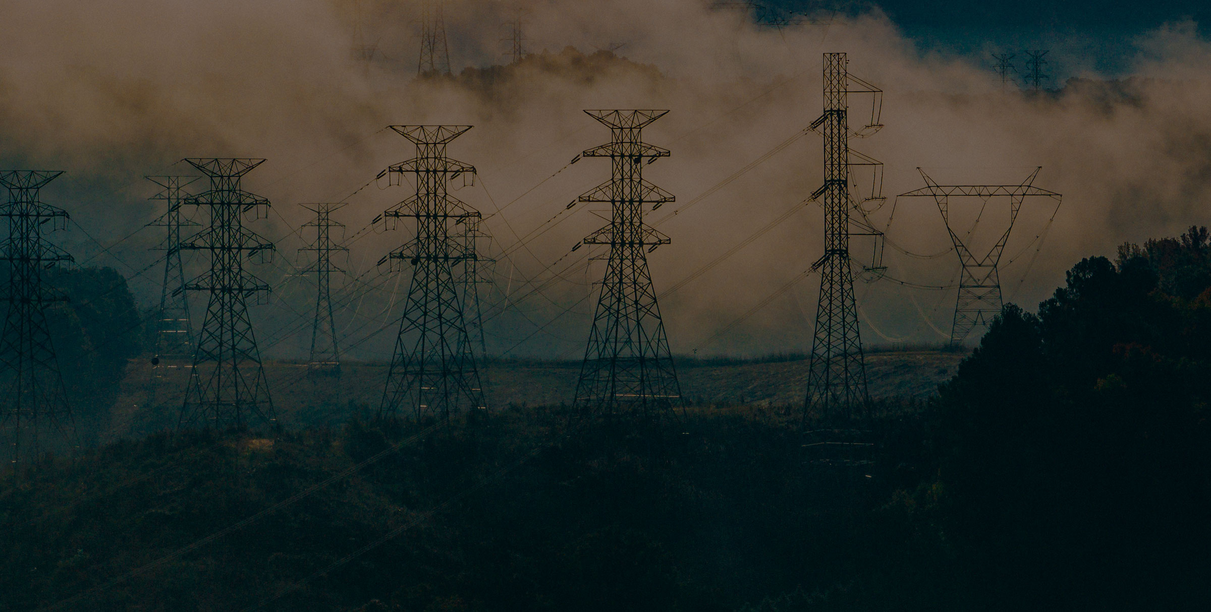Power lines with wildfire smoke in the background
