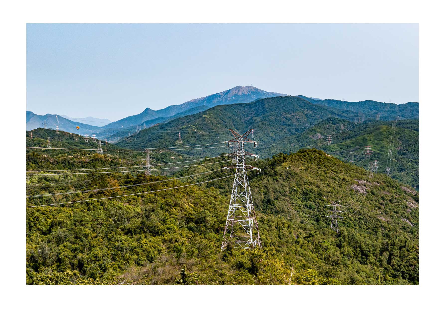 Power lines over green mountains