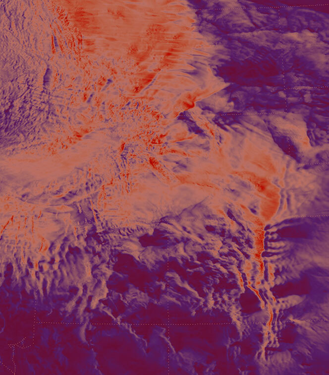 False-color satellite-style image showing rugged mountainous terrain with branching ridges and valleys. Warm reds and oranges highlight elevated areas, while deep purples and blues indicate lower regions or shadowed terrain.